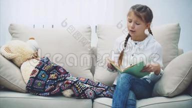 漂亮的小女孩为她的泰迪熊读童话故事，抚摸它，合上书，享受晚安，睡着了